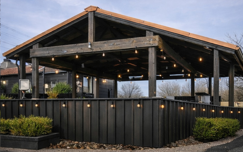 The covered timber pavilion glowing with string lights